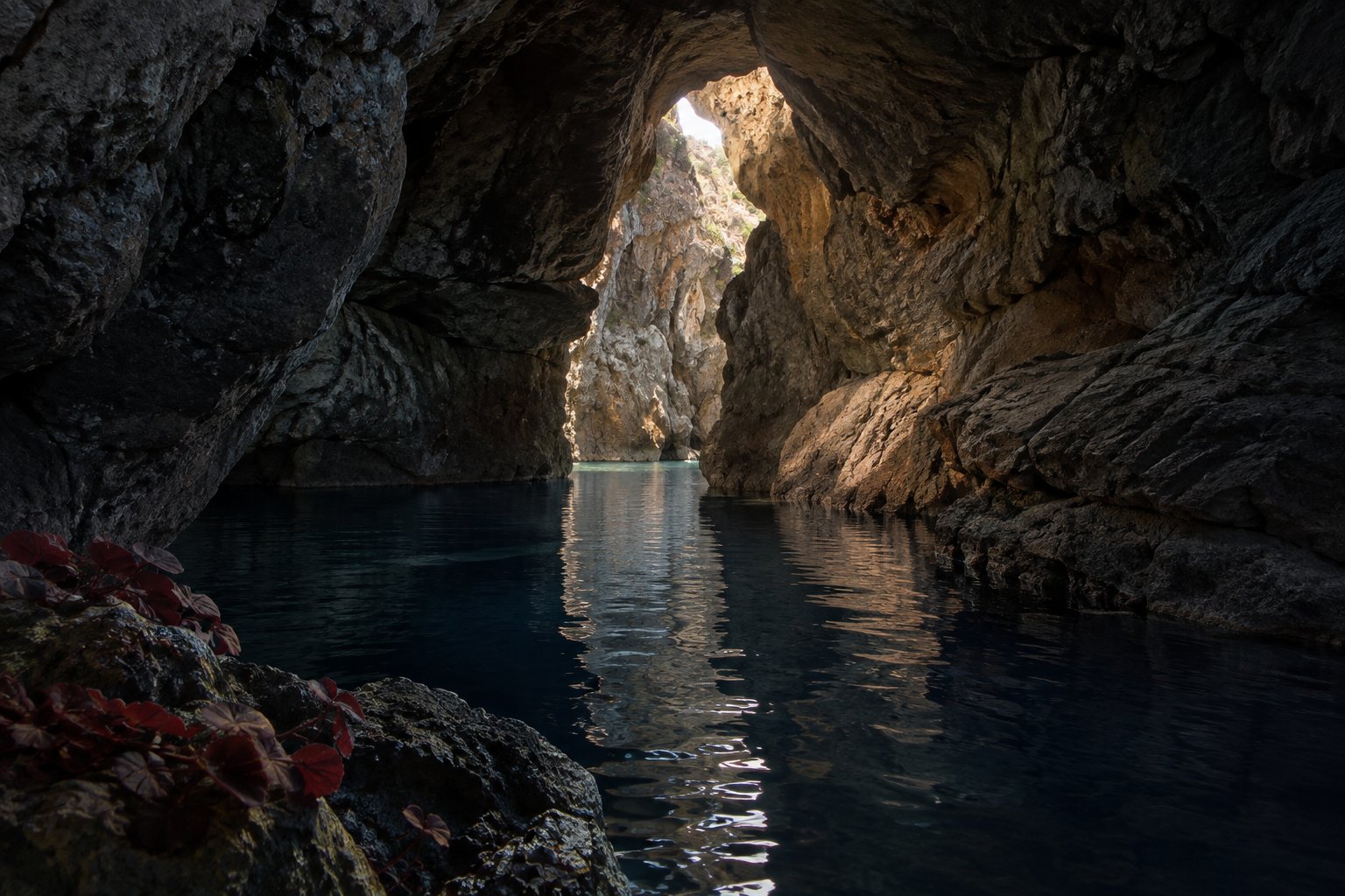 Gruta mediterránea con agua tranquila y una abertura iluminada
